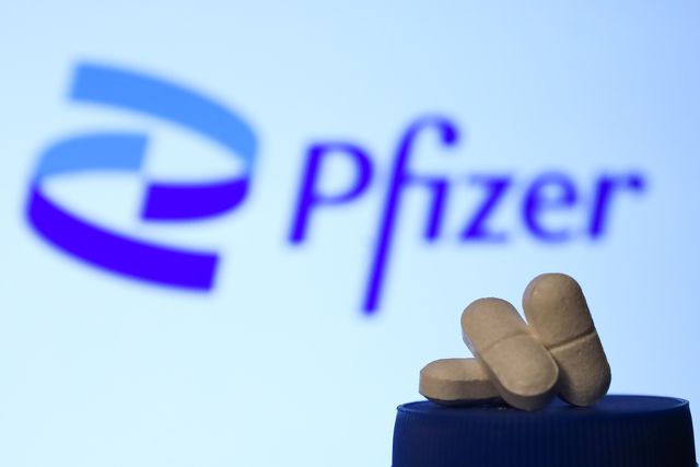 Generic pills shown in front of Pfizer logo.